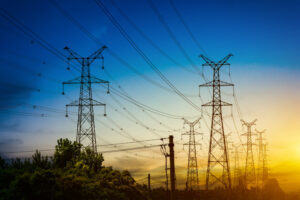 Ajuste do sol atrás da silhueta das torres de eletricidade